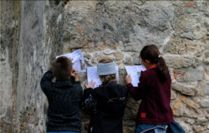 Žiaci vypĺňajúci materiál